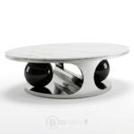 Table basse ovale moderne avec plateau en céramique claire et structure sculpturale en acier inoxydable argenté et noir, dimensions L130 × D70 × H45 cm